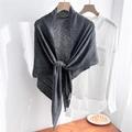 Detail of dark grey knitted shawl with delicate openwork pattern over a white shirt - Gray
