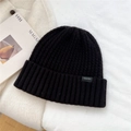 Close-up of black wool knit beanie featuring thick texture and BOWLOW brand woven label - One Size / Black