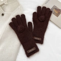 Close-up of plush dark brown knit gloves with soft floral accents and brand tag - Gloves / Brown