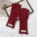 Detail of burgundy knit gloves with white speckles and a stylish woven fabric label - Confetti Red