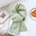 Detail shot of green chunky knit scarf with rib texture and branding label - Mélange Green