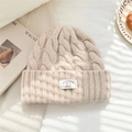 Close-up of beige 100% wool knit beanie with chunky cable texture and brand label - 25*22cm / Beige