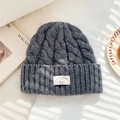 Detailed close-up of 100% wool knit beanie with woven brand label and cable stitch texture - 25*22cm / Gray