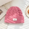 Detail of pink cable-knit wool beanie showing 100% wool label and thick texture - 25*22cm / Pink
