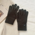 Close-up of dark grey knitted gloves with warm ribbed cuffs on a soft white fabric - One Size / Smoke