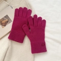 Close-up of magenta knitted gloves with elongated ribbed cuffs on a white fabric background - One Size / Rose Red
