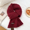 Detail of burgundy thick knit scarf showing chunky ribbed texture and leather brand patch - Burgundy