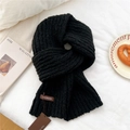 Close-up of black chunky knit scarf featuring a leather brand tag and cozy winter texture - Black