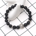 Detailed view of black volcanic lava stone beads and silver lion head charm on a hand model - Lava Stone With Silver Lion
