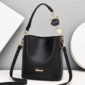 Minimalist black bucket bag with a gold logo and a blue cat pendant on a stylish strap - Black
