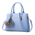 Light blue faux leather handbag with gold hardware and a fluffy grey pom-pom keychain - Light Blue