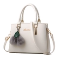 Elegant cream white faux leather handbag with golden hardware and plush pompom charm - Off White