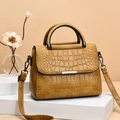 Elegant tan crocodile embossed handbag with silver metal bar and round top handle - Turmeric