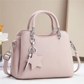 Pink lychee texture leather handbag with silver hardware and star charm on beige background - Purple