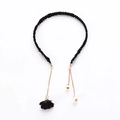 Detail view of black fabric headband featuring gold tassel chains and pearl pendants - Single Flower Style / Black