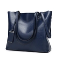 Detail of navy blue leather tote bag with dual handles and metal logo tag decoration - Dark Blue