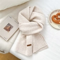Detail of soft cream knitted scarf featuring thick texture and brown leather label - 31*187cm / Creamy White