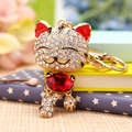 Golden cat keychain with clear crystals and a large red gemstone on a golden ring - Lucky Cat Red