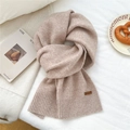 Detailed close-up of knit scarf texture with leather tag and ribbed edge in warm beige color - 31*187cm / Beige Coffee
