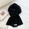 Close-up of black knitted scarf with vertical stripes and bow detail on fabric - Black Bow