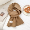 Nahaufnahme von kamelfarbenem Strickschal mit dezenten Farbtupfern und Markenetikett - 23*160cm / Camel