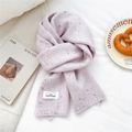 Detail eines fliederfarbenen Strickschals mit Konfetti-Muster und gewebtem Etikett - 23*160cm / Rosa