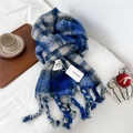 Dettaglio di una sciarpa in maglia a quadri blu e grigi con lunghe nappe su un letto - 32x235cm (Incluse Nappe) / Quadri Blu e Beige