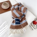 Detail of wool blend striped scarf with thick tassels and brand label on soft surface - Brown and Blue Striped