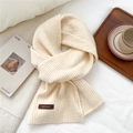 Dettaglio della sciarpa in maglia a coste bianco crema con etichetta decorativa in pelle marrone - 26*180cm / Bianco latte