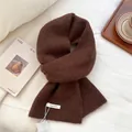 Close-up of deep brown wool-blend knit scarf with rich texture and brand woven label - Brown