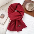 Close-up of dark red chunky knit scarf with vertical stripes and stylish logo tag - 26*180cm / Red