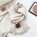 Close-up of off-white wool knit scarf with fringe trim and premium brand label detail - Off White