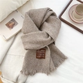 Dettaglio sciarpa di lana marrone con etichetta fatta a mano e nappe decorative - 32x190cm / caffè