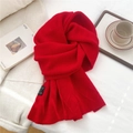 Dettaglio macro della sciarpa in maglia rossa con motivo a rombi ed etichetta su tessuto - Rosso