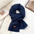 Detailed view of dark blue knitted scarf featuring a brown leather patch on soft wool texture - Dark Navy(06)