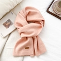 Detailed texture of light pink knit scarf with a brown leather logo tag on a soft surface - Pale Pink(08)