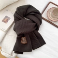 Close-up of dark brown ribbed knit scarf with hand-stitched label on soft fabric - 185x30cm / Dark Brown