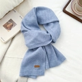 Detail view of light blue knitted scarf texture and premium leather label on fabric - Light Blue (12)