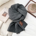 Close-up of thick dark grey wool knit scarf texture with a handmade decorative label - One Size / Heathered Dark Gray