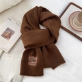 Close-up of thick knitted wool scarf showing detail of handmade woven label on fabric - One Size / Heathered Brown