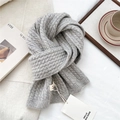 Dettaglio di sciarpa grigia in maglia spessa con trama a trecce su tessuto bianco - 150x23cm / Grigio chiaro