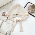 Close-up of beige knit hooded scarf showing ribbed texture and minimalist brand label - Cream