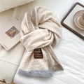 Close-up of cream knit scarf with wool fabric detail, color block edges and artisan label - Beige Border Style