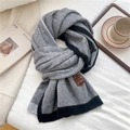 Detail of grey knitted scarf with black ribbed edges and brown leather brand label - Grey Border Style