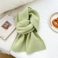 Soft mint green knitted scarf with button detail in a cozy home setting - Yellow-Green