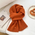 Soft orange wool knit scarf with ribbed texture and decorative branding tag for winter - Orange