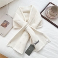 Close-up of cream knit scarf featuring chunky cable pattern and button closure - Creamy White