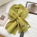 Close-up of avocado green chunky knit scarf with cross-slot design and decorative button - Yellow & Green