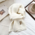 Detail of soft cream knitted scarf featuring a premium brown leather brand logo label - Creamy White