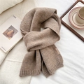 Close-up of soft camel knit scarf texture with a stylish leather logo label on white linen - Dark Coffee